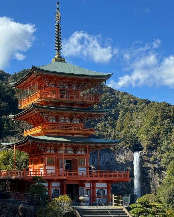 Pagoda al costat d'una cascada, entre vessants boscosos